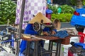 Vietnamese woman in a private sewing workshop repairing clothes, An unidentified tailor works at his sewing machine on the street Royalty Free Stock Photo