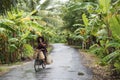 A Vietnamese woman rides her bicycle on a countryside road in the Mekong Delta.