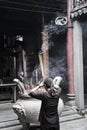 Vietnamese woman seen from behind prays at Chua Ba Thien Hau temple in Ho Chi Minh City, Vietnam