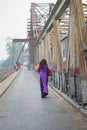 Vietnamese woman in traditional dress Ao Dai walking on old Long Bien bridge, Hanoi city