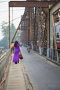 Vietnamese woman in traditional dress Ao Dai walking on old Long Bien bridge, Hanoi city