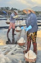 Vietnamese women are burdening hard to collect salt from the extract fields to the storage fields