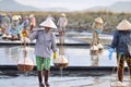 Vietnamese women are burdening hard to collect salt from the extract fields to the storage fields Royalty Free Stock Photo