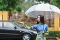 Vietnamese women wear Ao dai holding umbrella in the rain