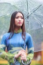 Vietnamese women wear Ao dai holding umbrella in the rain