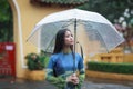 Vietnamese women wear Ao dai holding umbrella in the rain