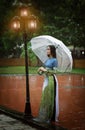 Vietnamese women wear Ao dai holding umbrella in the rain