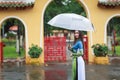 Vietnamese women wear Ao dai holding umbrella in the rain