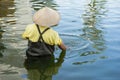 Vietnamese worker cleaning rubbish on lake. Manual work Royalty Free Stock Photo