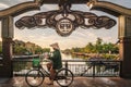 Vietnamise woman crossing the gate of Hoi an in bicycle dressing the tipycal hat