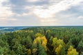 A view from above of the autumn forest and the sky with clouds before sunset in autumn. Deciduous and coniferous trees Royalty Free Stock Photo