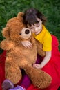 View from above. beautiful baby girl in a yellow T-shirt hugs a teddy bear Royalty Free Stock Photo