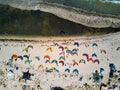 View from above of bright colorful kites lying parked on beach on windy day at kitesurfing spot. A lot of parachutes for Royalty Free Stock Photo