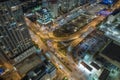 View from above of brightly illuminated city street with dense traffic and high skyscraper buildings in downtown of