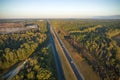 View from above of busy american highway with fast moving traffic between autumn woods. Interstate transportation
