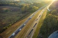 View from above of busy american highway with fast moving traffic between autumn woods. Interstate transportation