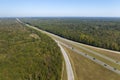 View from above of busy american highway with fast moving traffic between woods. Interstate transportation concept Royalty Free Stock Photo