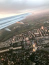 A view from above of the city with buildings, houses from the porthole, aircraft windows on the wing with engines, turbines and wh