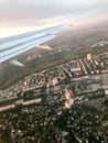 A view from above of the city with buildings, houses from the porthole, aircraft windows on the wing with engines, turbines and wh