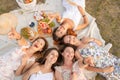 View from above. Company of beautiful girlfriends have fun and enjoy a picnic outdoors