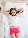 View from above on cute girl lying on bed and looking at camera Royalty Free Stock Photo