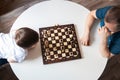 View from above Dad and son are playing a board game of chess. Time and games with children. Logic and strategy game. Authentic Royalty Free Stock Photo