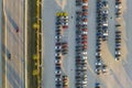 View from above of dealers outdoor parking lot with many brand new cars in stock for sale on highway side. Concept of