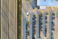 View from above of dealers outdoor parking lot with many brand new cars in stock for sale on highway side. Concept of Royalty Free Stock Photo