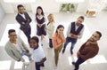 View from above of diverse team of happy young people standing in office, looking up and smiling Royalty Free Stock Photo