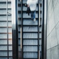 View from above on fast moving young man walking up an escalator stairs Royalty Free Stock Photo