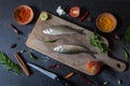 View from above of fish with vegetables and spices on a wooden board Royalty Free Stock Photo