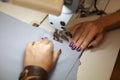 View from above on hands of female tailor working on sewing machine. dress manufacturing industry