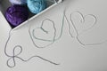 View from above on hearts from colorful wool strands coming out of the white box with knitting yarn balls. Royalty Free Stock Photo