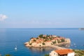 View from above of island and St. Stefan's beach in Budva. Blue sky and sea with boats and sailboats, sunny day