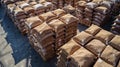 A view from above of a large warehouse filled with stacks of wooden pallets loaded with bags of biomass pellets. The Royalty Free Stock Photo