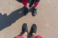 A view from above on the legs of a man and a woman standing opposite each other on a beach sand in summer Royalty Free Stock Photo