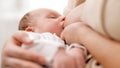 View from above on newborn baby boy sucking milk from mother's breast. Concept of healthy and natural baby breastfeeding Royalty Free Stock Photo