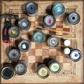 View from above of paint tins, brushes and hammer on chess board table Royalty Free Stock Photo