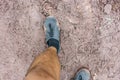 View from above on pair of trekking shoes in a mud, Hiking boots stuck in mud