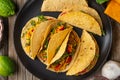 View from above of plate with mexican tacos on rustic wooden table background. Concept of traditional meal. Appetizing photo for