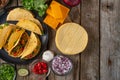 View from above of plate with mexican tacos on rustic wooden table with ingredients for cooking background. Concept of traditional Royalty Free Stock Photo