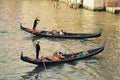 Romantic city of venice at sunset with three gondoliers on water