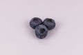 View from above on several three blue berries on white background