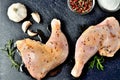 View from above of spicy raw chicken legs on a cutting board ready for baking with a fresh rosemary, garlic, cumin Royalty Free Stock Photo