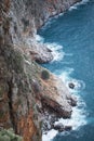 View from above of steep slopes with pine trees and rocky Mediterranean sea shore