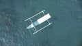 View from above, stunning aerial view of a Bangka floating on a turquoise, crystal clear sea. A Bangka is a double outrigger canoe Royalty Free Stock Photo