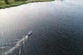 Aerial view of sailing white yacht in sea next to a green coastline Royalty Free Stock Photo