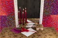 Candles reflecting in the mirror, paper and feather. Royalty Free Stock Photo