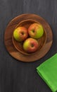 View from above on three ripe apples that lie in a small wooden bowl Royalty Free Stock Photo