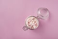 View from above of white and pink marshmallows in glass jar